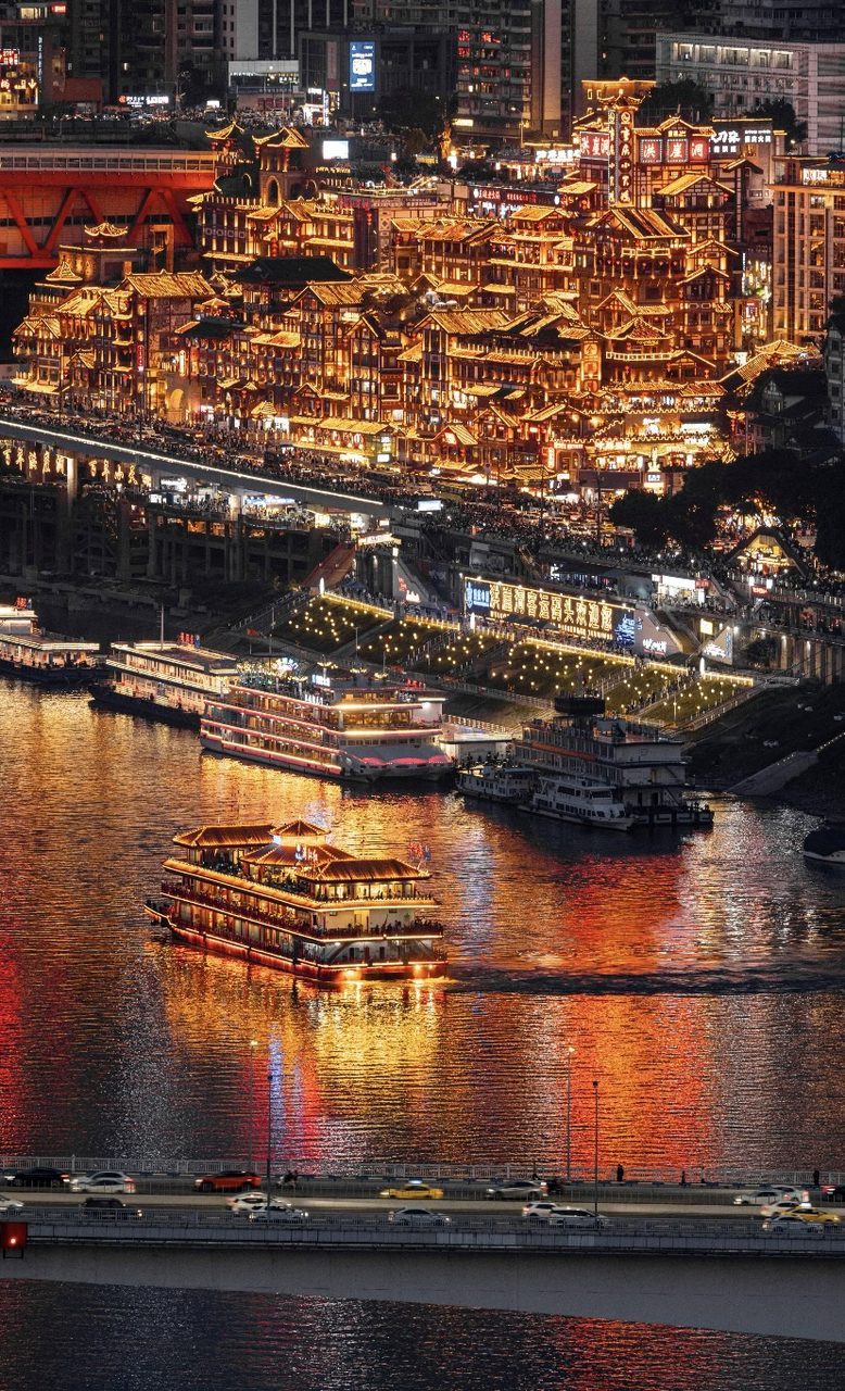 Hongyadong glowing gold over the river at night