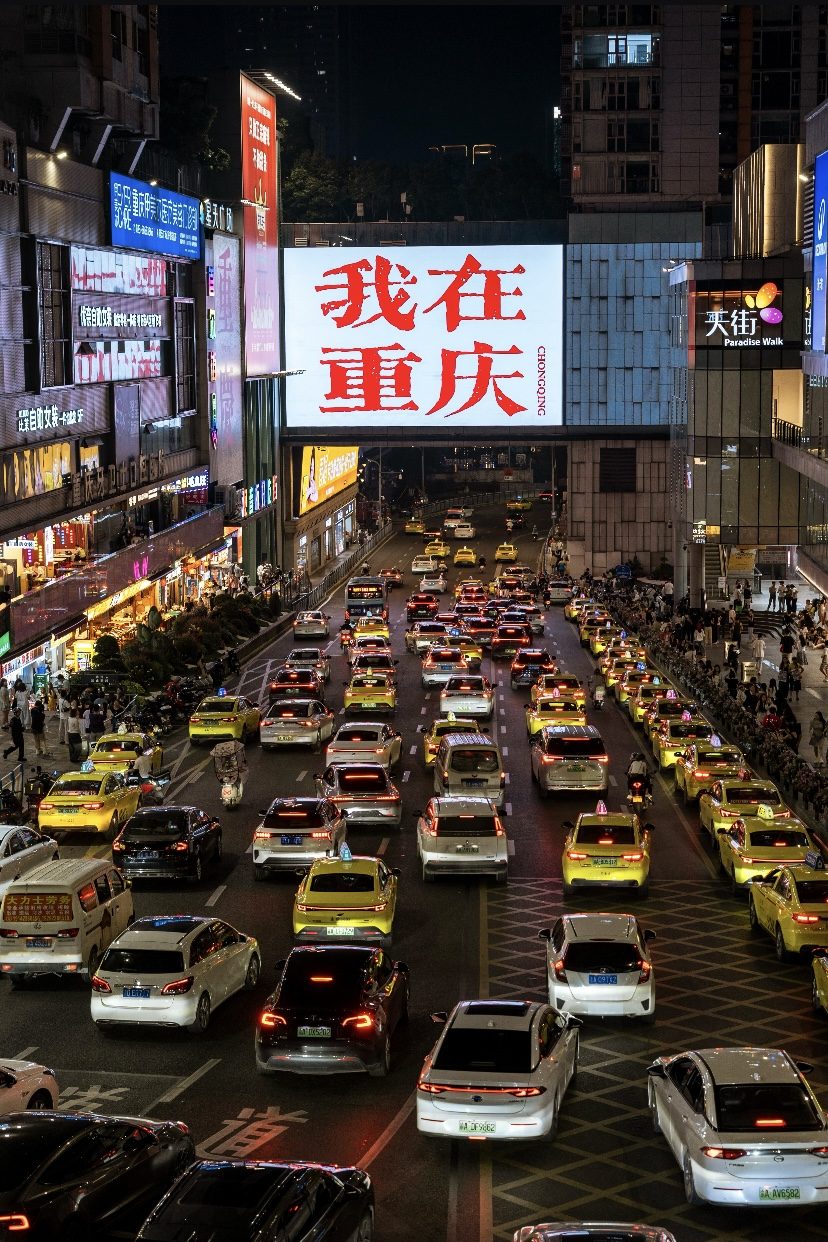 A lively illuminated Chongqing plaza at night