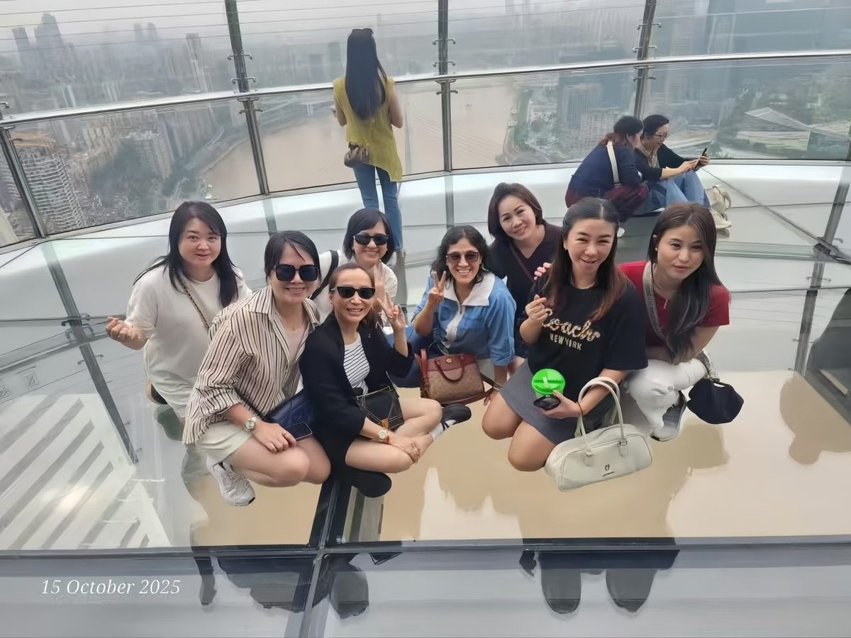 Travellers on the Raffles glass skywalk over the Chongqing rivers